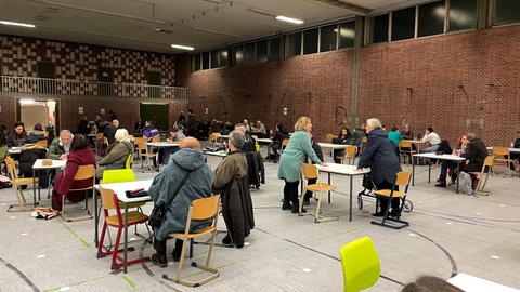 Die evakuierten Menschen saßen an Tischen in der Sporthalle des Kepler-Gymnasiums in Ulm. Sie mussten ihre Wohnungen wegen dem Fund einer Fliegerbombe verlassen.