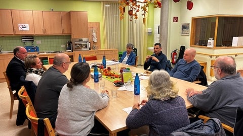 Zehn Menschen, Betroffene und Angehörige sitzen gemeinsam am Tisch. Die Schlaganfall-Selbsthilfegruppe von Ralf Illing trifft sich einmal im Monat.