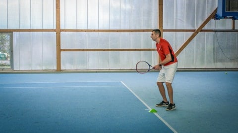 Ralf Illing steht auf dem Tennisplatz und schaut konzentriert auf sein Gegenüber auf der anderen Seite des Netzes. Hier wieder zu stehen hat viel harte Arbeit gekostet.