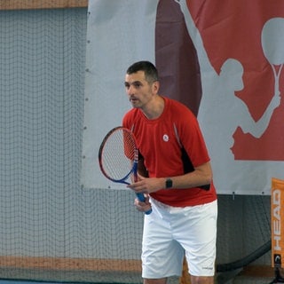 Ralf Illing, Tennisschläger fest in der Hand, blickt fokussiert nach vorne. Der Weg zurück auf den Tennisplatz war für ihn nach dem Schlaganfall nicht leicht.