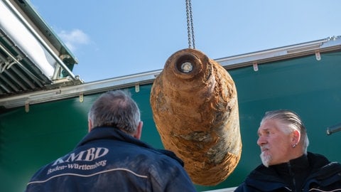 Wolfgang Kosiol (li.) und Harald Nestle (re.), Mitarbeiter des Kampfmittelbeseitigungsdienstes Baden-Württemberg, verladen im März 2022 eine entschärfte Fliegerbombe. Wegen der Entschärfung der rund 1000 Kilo schweren Fliegerbombe mussten in Aalen mehr als 3000 Bewohner im Umkreis von 600 Metern um die Fundstelle ihre Häuser und Wohnungen für mehrere Stunden verlassen.