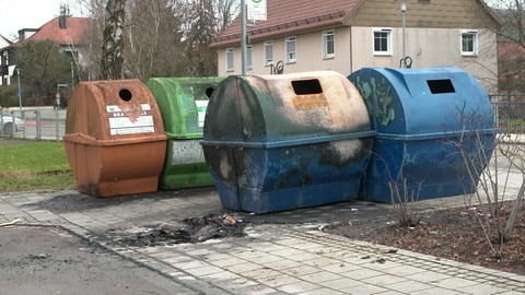 Auf einem blauen Papiercontainer in Langenau lassen sich deutlich verkohlte Stellen erkennen. Neben dem Mülleimer ist außerdem ein verbrannter Haufen zu sehen. Es ist eine von fünf Stellen, an denen Unbekannte in der Nacht auf Sonntag Müllcontainer entzündet haben. Ob die Taten in Zusammenhang mit judenfeindlichen Schmierereien stehen, ermitteln Polizei und Staatsschutz.