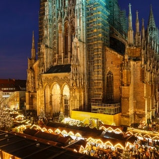 Der hell erleuchtete Weihnachtsmarkt in Ulm bei Nacht - Organisator und Standbetreiber ziehen eine positive Bilanz für 2024. nach dem Anschlag in Magdeburg wurden die Sicherheitsvorkehrungen aber nochmals erhöht. 