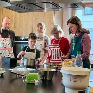 Mehrere Menschen stehen um einen Tisch. Sie alle haben beim Kurs im Merklinger Backhaus mitgemacht. Auf dem Speiseplan stand die Merklinger Nudel.