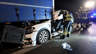 Ein weißes Auto teilweise unter einem Lastwagen: Auf der rechten Fahrspur der A8 bei Dornstadt ist ein Autofahrer auf einen Lastwagen aufgefahren. Das Auto verkantete sich und wurde mitgeschleift.