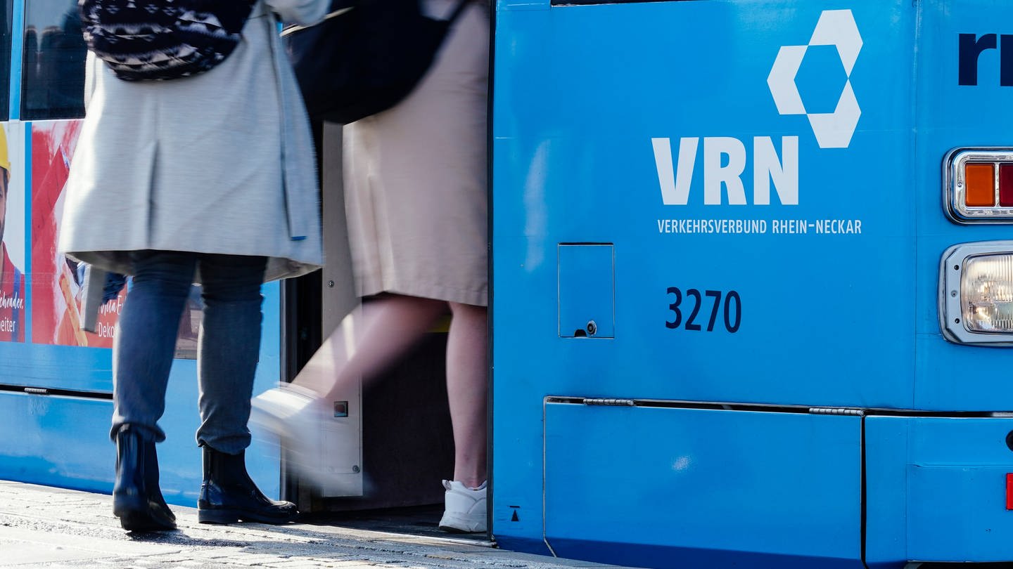 Frauen steigen an einer Straßenbahnhaltestelle in eine Straßenbahn ein