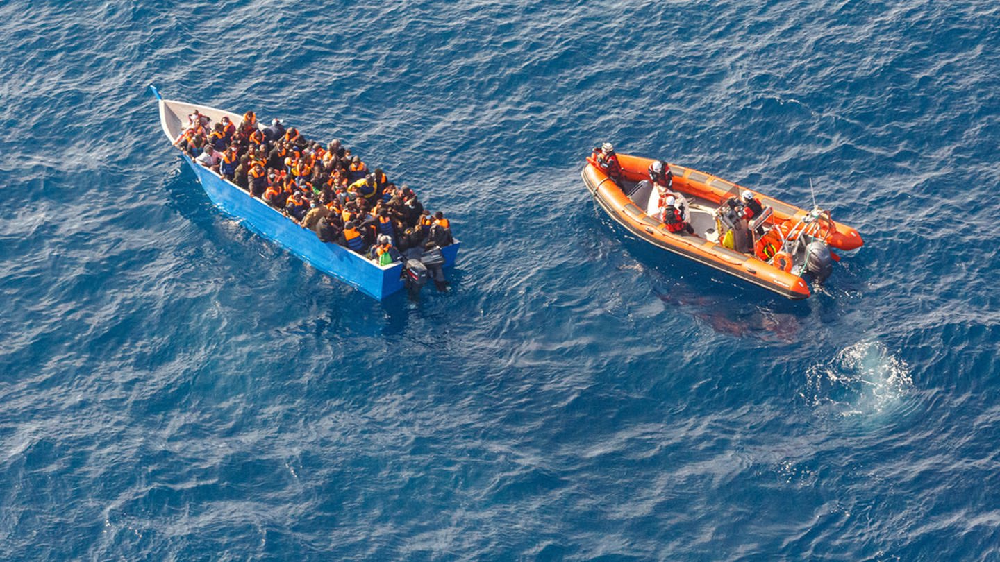 Ein Rettungsboot der Sea-Watch 3 nähern sich einem Boot mit 97 Migranten