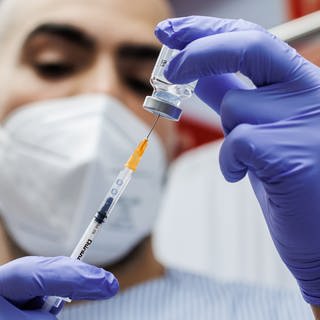 Ein Krankenpfleger bereitet eine Auffrischungsdosis des Corona-Impfstoffs von Moderna vor, der an die Omikron-Sublinie BA.1 angepasst ist.
