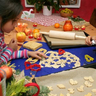 Die beiden sechsjährigen Kinder Le-Ly und Damian backen in der heimischen Küche im brandenburgischen Sieversdorf (Oder-Spree) Weihnachtsplätzchen