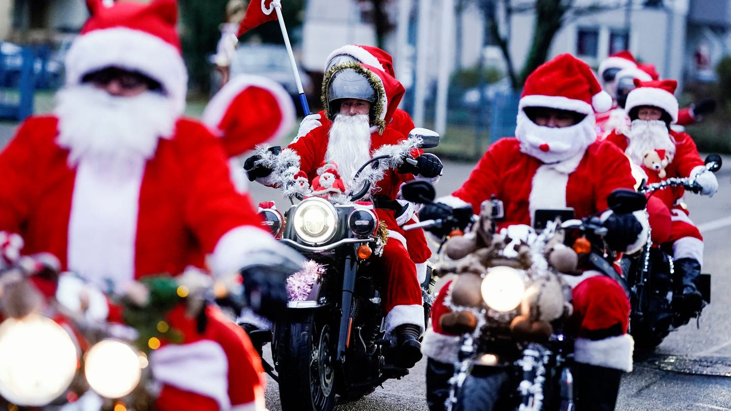 Als Weihnachtsmänner verkleidete Motorradfahrer der Harley Davidson riding Santas fahren über eine Straße.