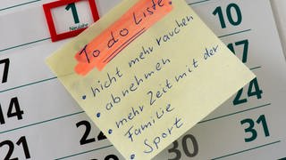 Auf dem 1. Januar (Neujahr) eines Kalenders klebt eine «To do Liste» mit den Vorsätzen «nicht mehr rauchen, abnehmen, mehr Zeit mit der Familie und Sport».