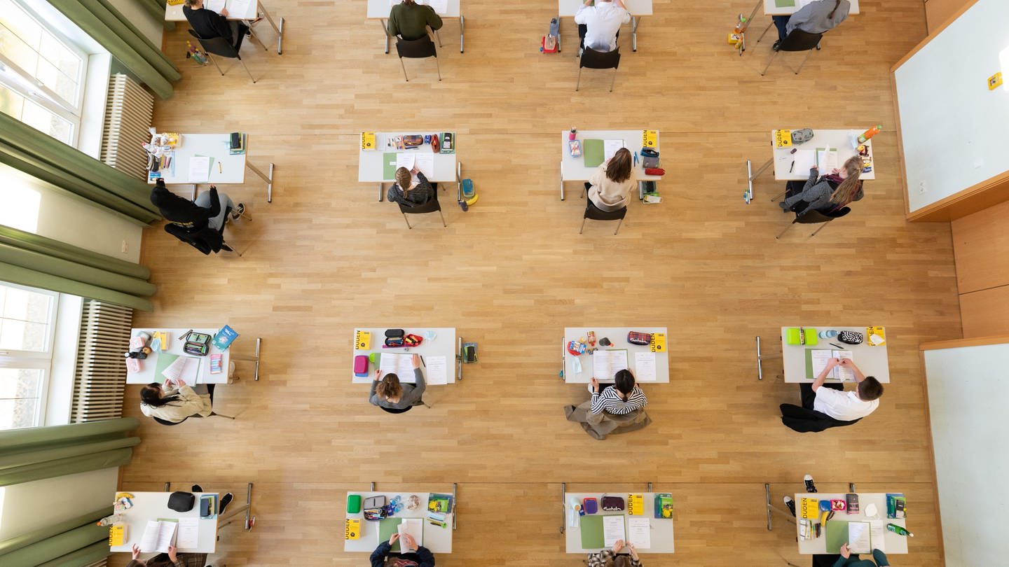 Schüler sitzen in der schriftlichen Abiturprüfung.