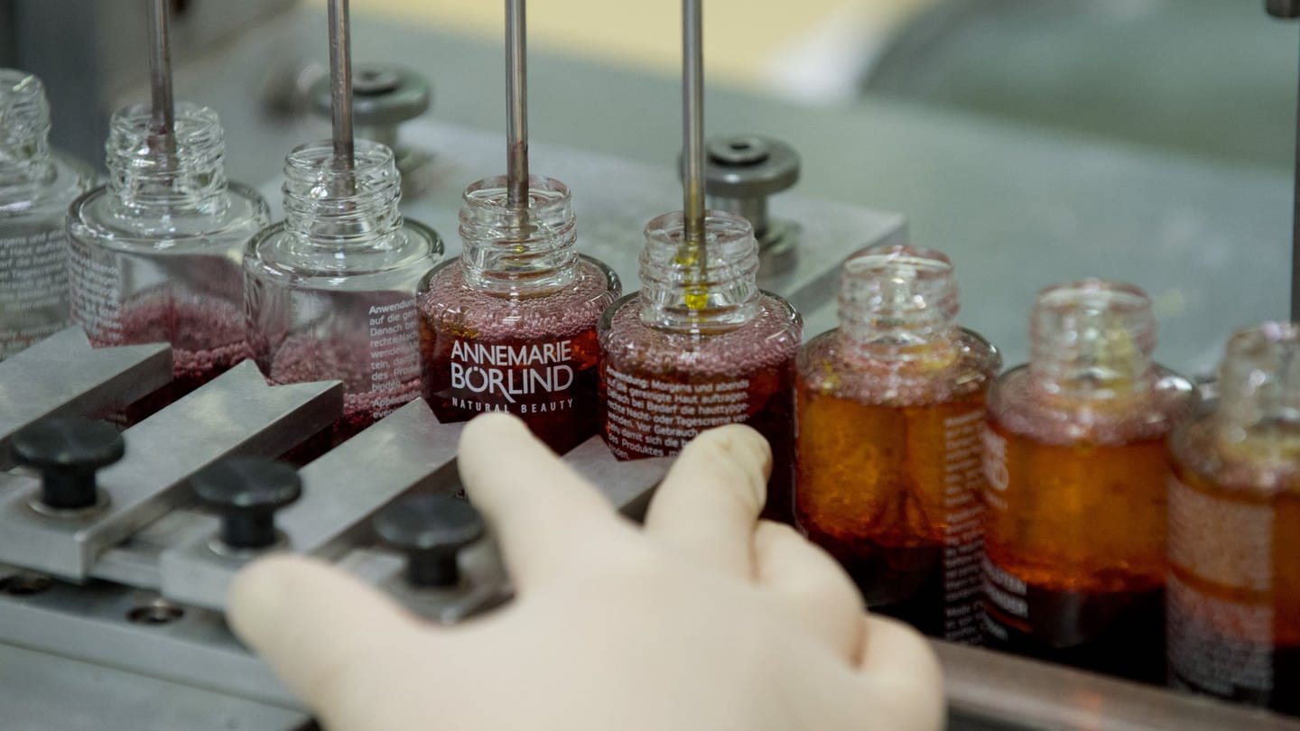 Glasfläschchen der Börlind GmbH werden in der Produktion des Naturkosmetikherstellers in Calw (Baden-Württemberg) mit Kosmetik befüllt.