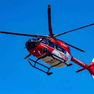 Der Rettungshubschrauber vom Typ H145 mit der Kennung D-HXFF der Deutschen Rettungsflugwacht (DRF) fliegt über einer DRF-Station.