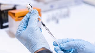 Ein Mitarbeiter eines mobilen Impfteams vom Arbeiter-Samariter-Bund (ASB) zieht eine Spritze mit dem BA.4BA.5-Impfstoff von Biontech gegen das Corona-Virus in einem Impfzentrum.