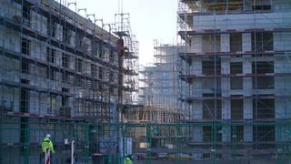 Bauarbeiter arbeiten auf der Baustelle eines neuen Stadtquartiers in einer deutschen Großstadt.