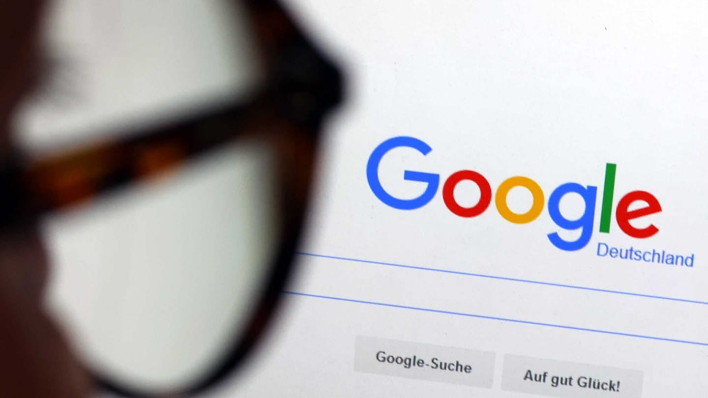 ILLUSTRATION - Die Seite der Suchmaschine von Google ist hinter einer Frau mit Brille zu sehen.
