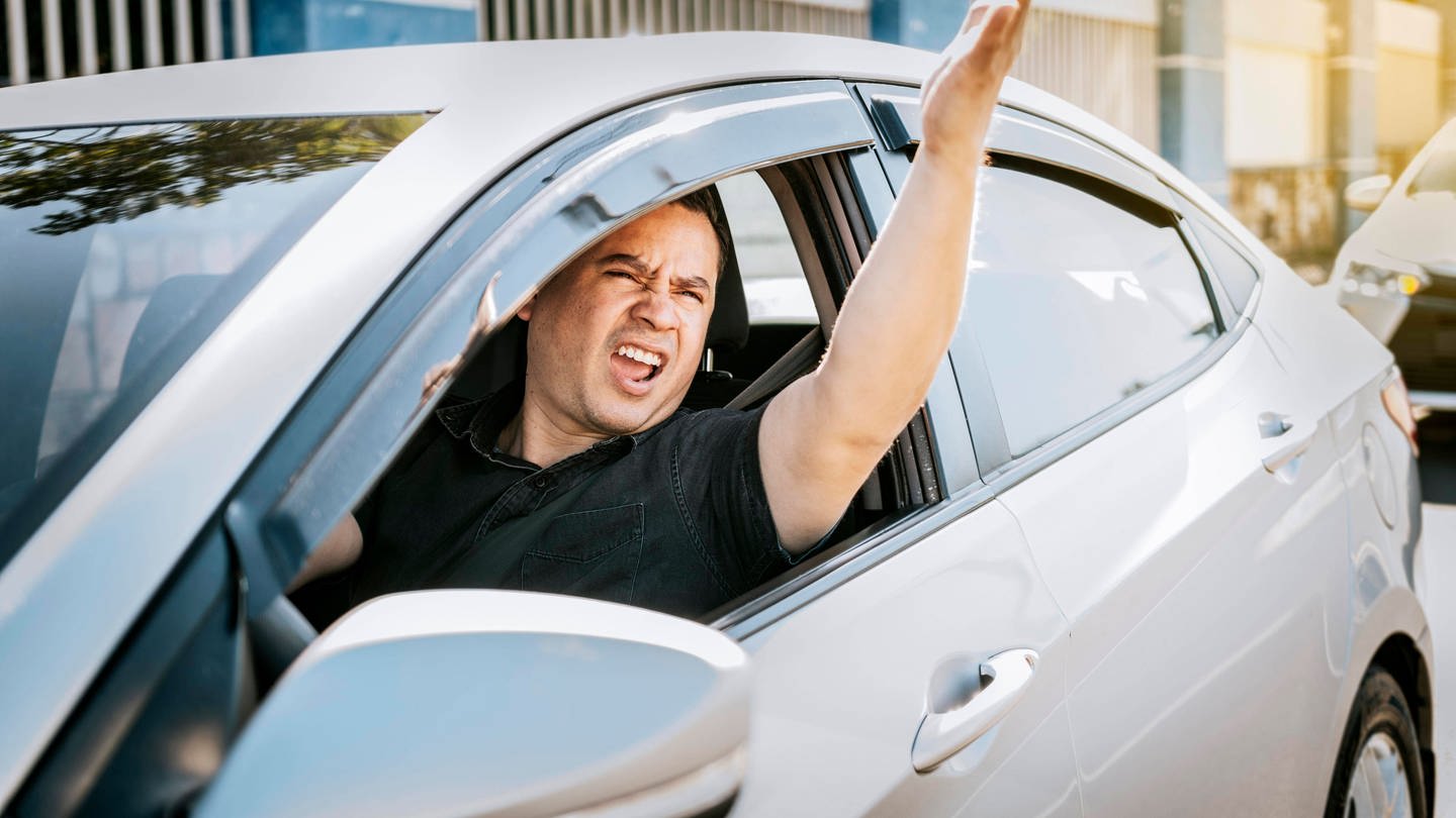 Ein Autofahrer gibt Handzeichen