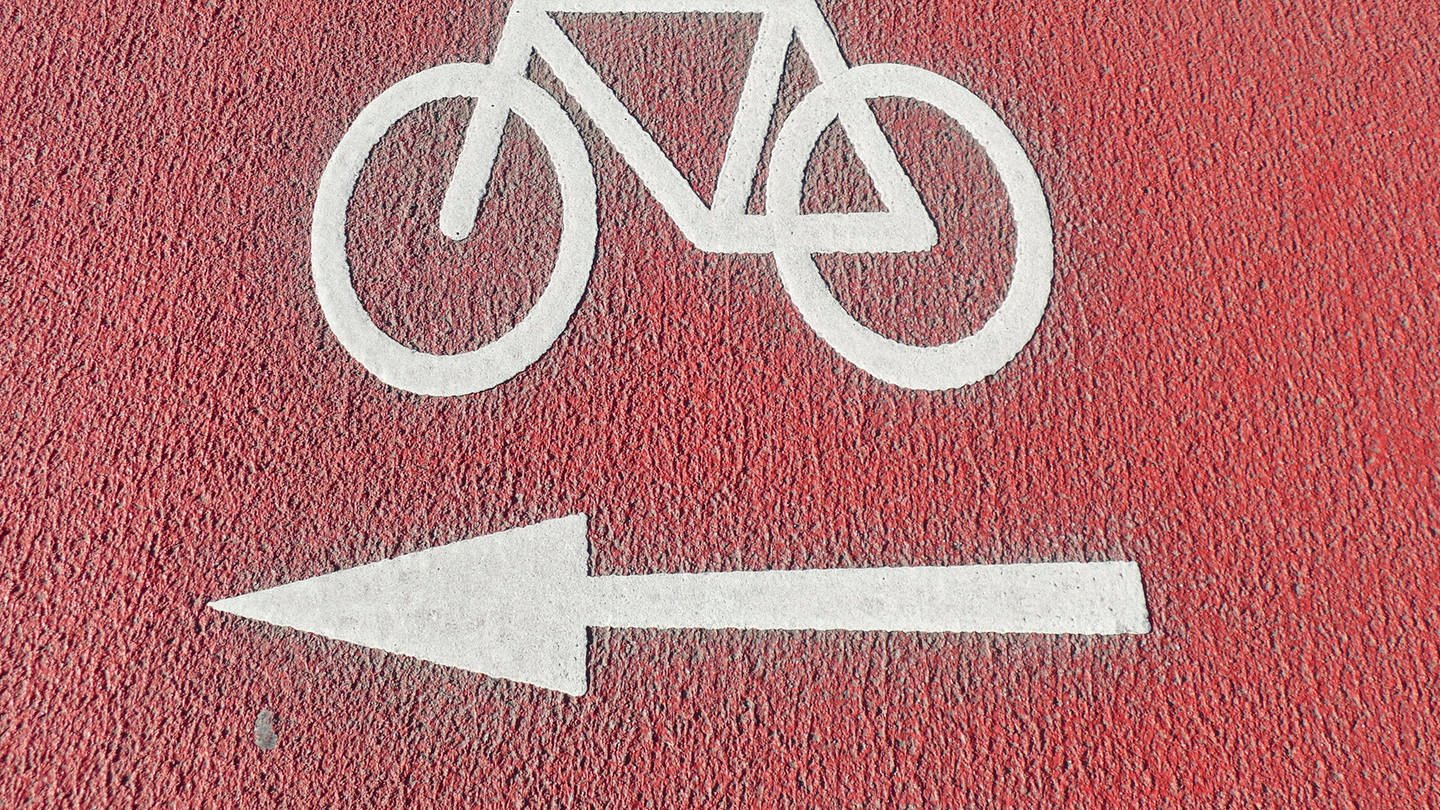 Ein rot markierter Radweg mit einem weißen Fahrradsymbol