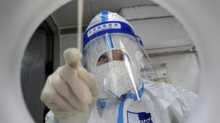Ein Labormitarbeiter führt einen PCR-Test durch