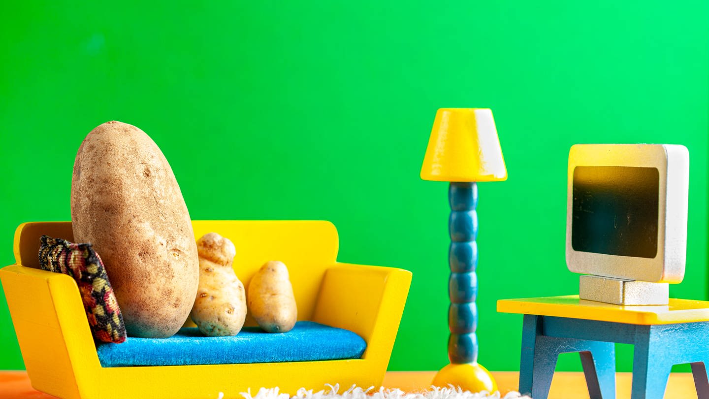 Eine Kartoffelfamilie sitzt auf einer Modell-Couch.