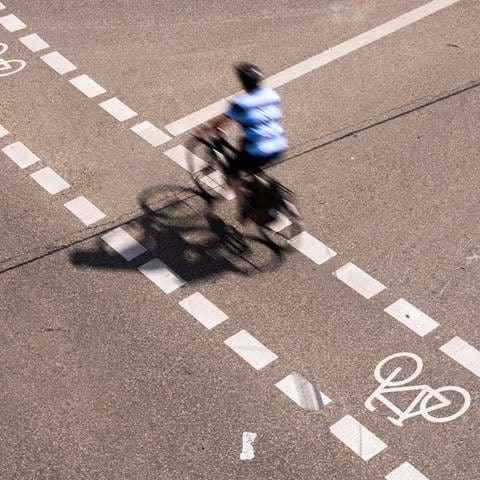 Ein Radfahrer fährt in der Innenstadt von Freiburg auf einem Fahrradschutzstreifen.