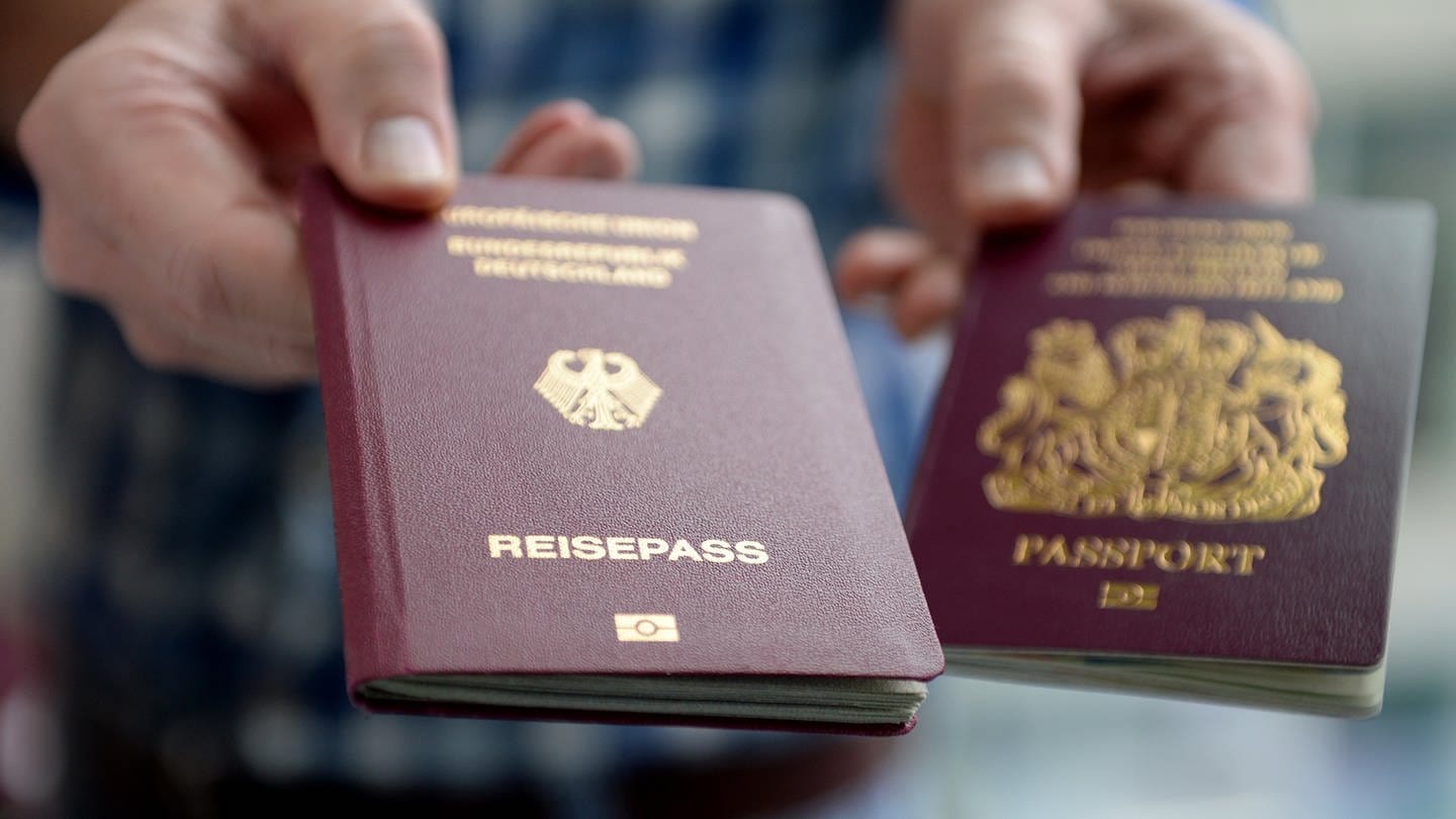 Hand hält einen deutschen Reisepass.