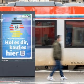 Die Werbung für das Deutschlandticket ist an einem Bahnsteig vor einer Bahn des ÖPNV zu sehen.