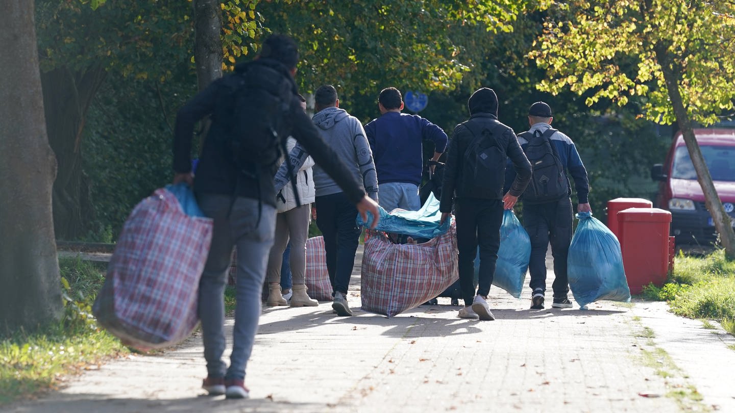 Flüchtlinge aus Syrien gehen mit ihrem Gepäck zu der Flüchtlingsunterkunft im Alma-Ohlmann-Weg im Hamburger Stadtteil Lokstedt. Der Flüchtlingszustrom im Norden dauert an. Die Hansestadt prüft die Unterbringung in Gewerbehallen und Zelten.