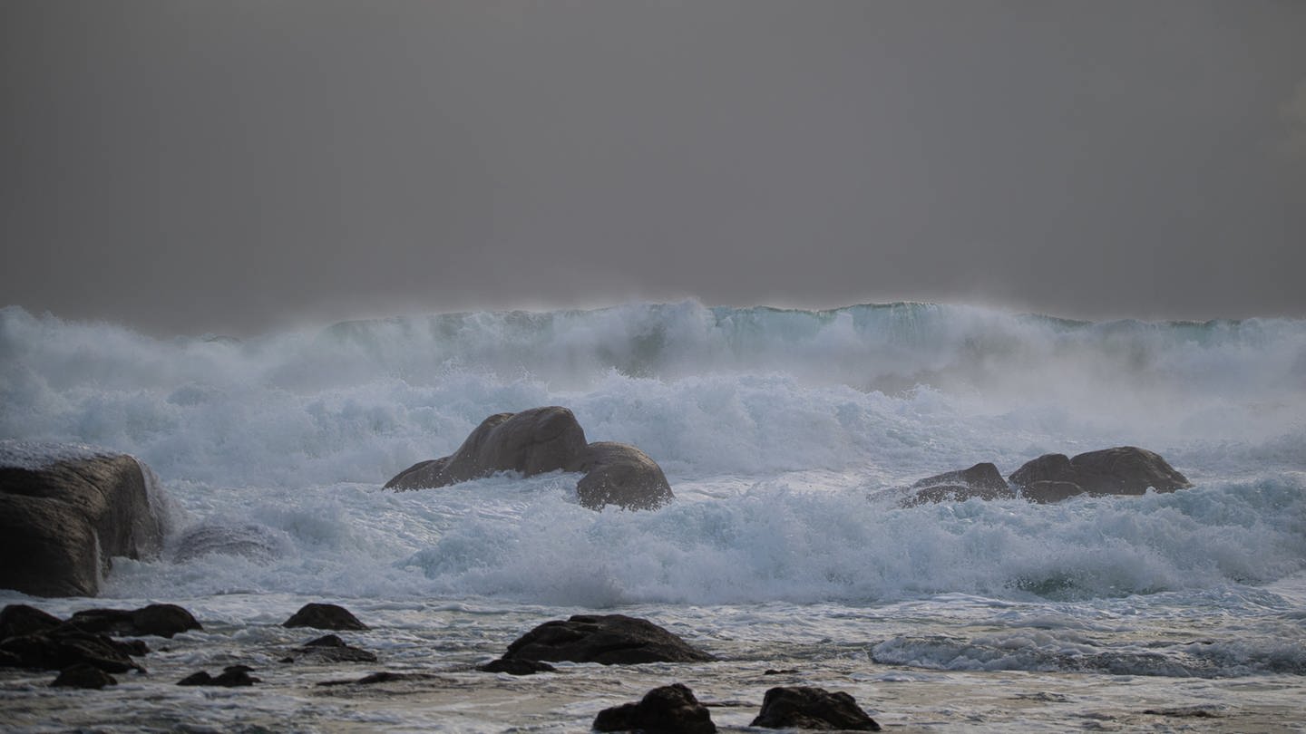 Wellen brechen in Richtung eines Strandes.