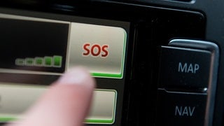 SYMBOLBILD - Ein Schriftzug "SOS" ist auf dem Display eines Bordcomputers mit Touchpad eines Volkswagen Fahrzeuges zu sehen.