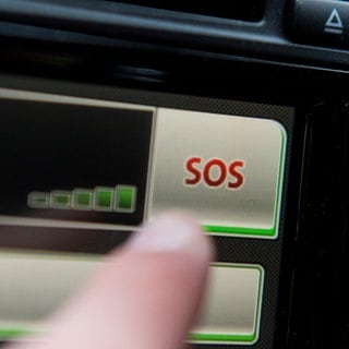 SYMBOLBILD - Ein Schriftzug "SOS" ist auf dem Display eines Bordcomputers mit Touchpad eines Volkswagen Fahrzeuges zu sehen.