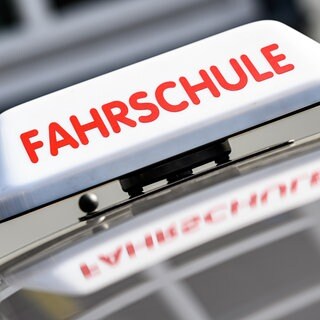 Ein Dachzeichen mit der Aufschrift "Fahrschule" ist an einem Fahrschulauto angebracht.