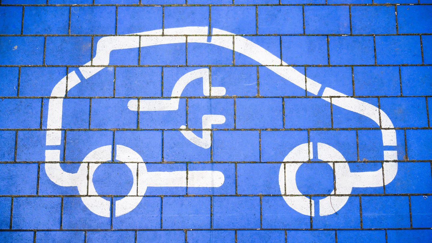 Ein blaues Symbol mit einer Steckdose für ein Auto steht für Batterietechnik im Automobilbereich