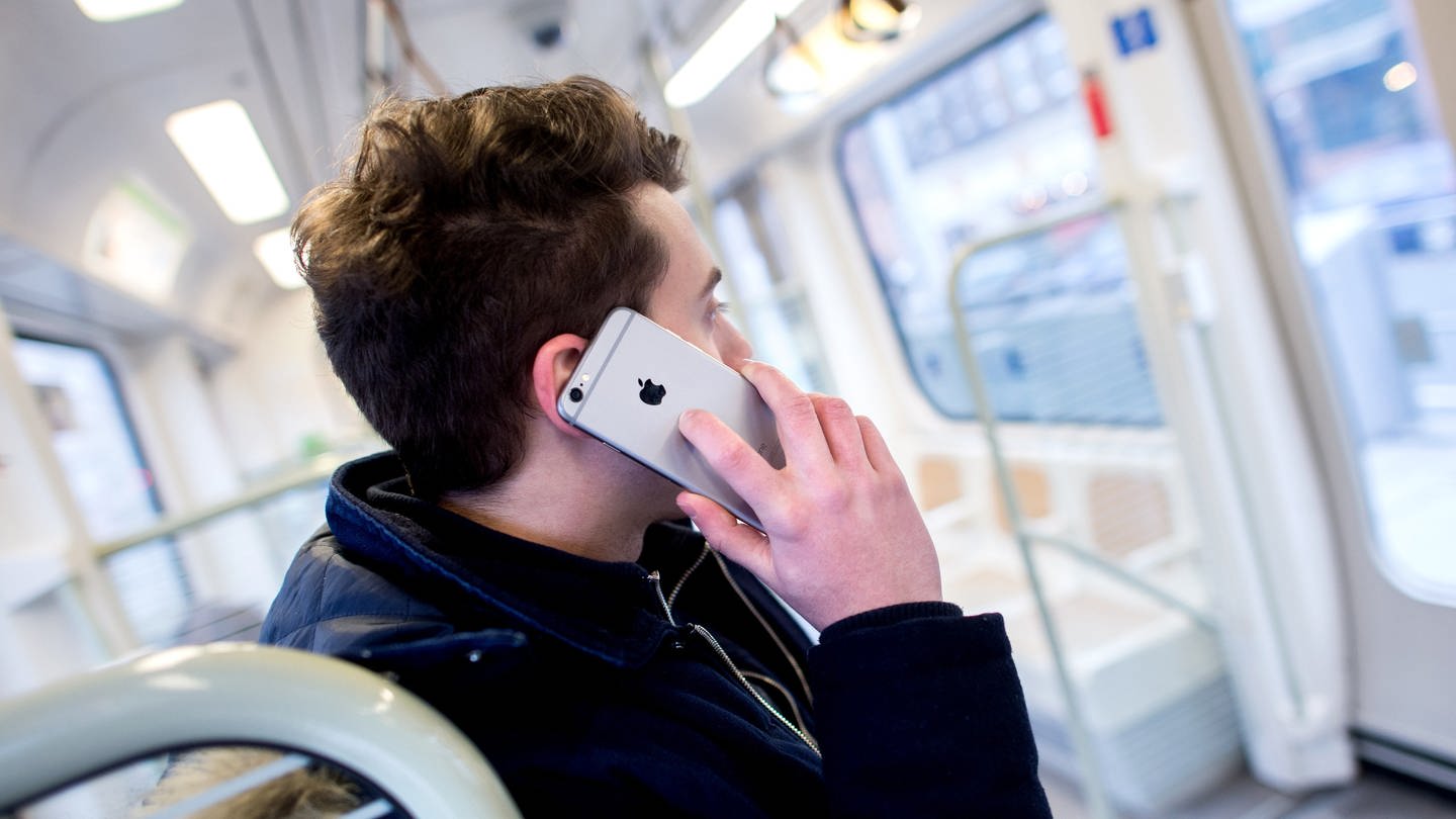 ILLUSTRATION - Ein junger Mann steht am 08.02.2017 in Hannover (Niedersachsen) in einer Stadtbahn und telefoniert dabei mit seinem Smartphone.