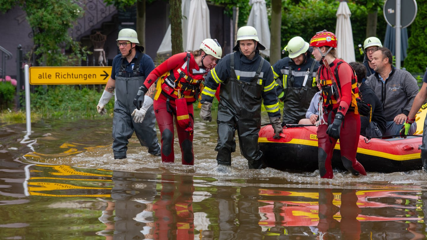 Mit einem Schlauchboot holen Feuerwehr und Wasserretter Anwohner aus ihren überfluteten Häusern. Nach dem Starkregen der letzten Tage kam es zu schweren Überschwemmungen im Süden von Baden-Württemberg und Bayern.