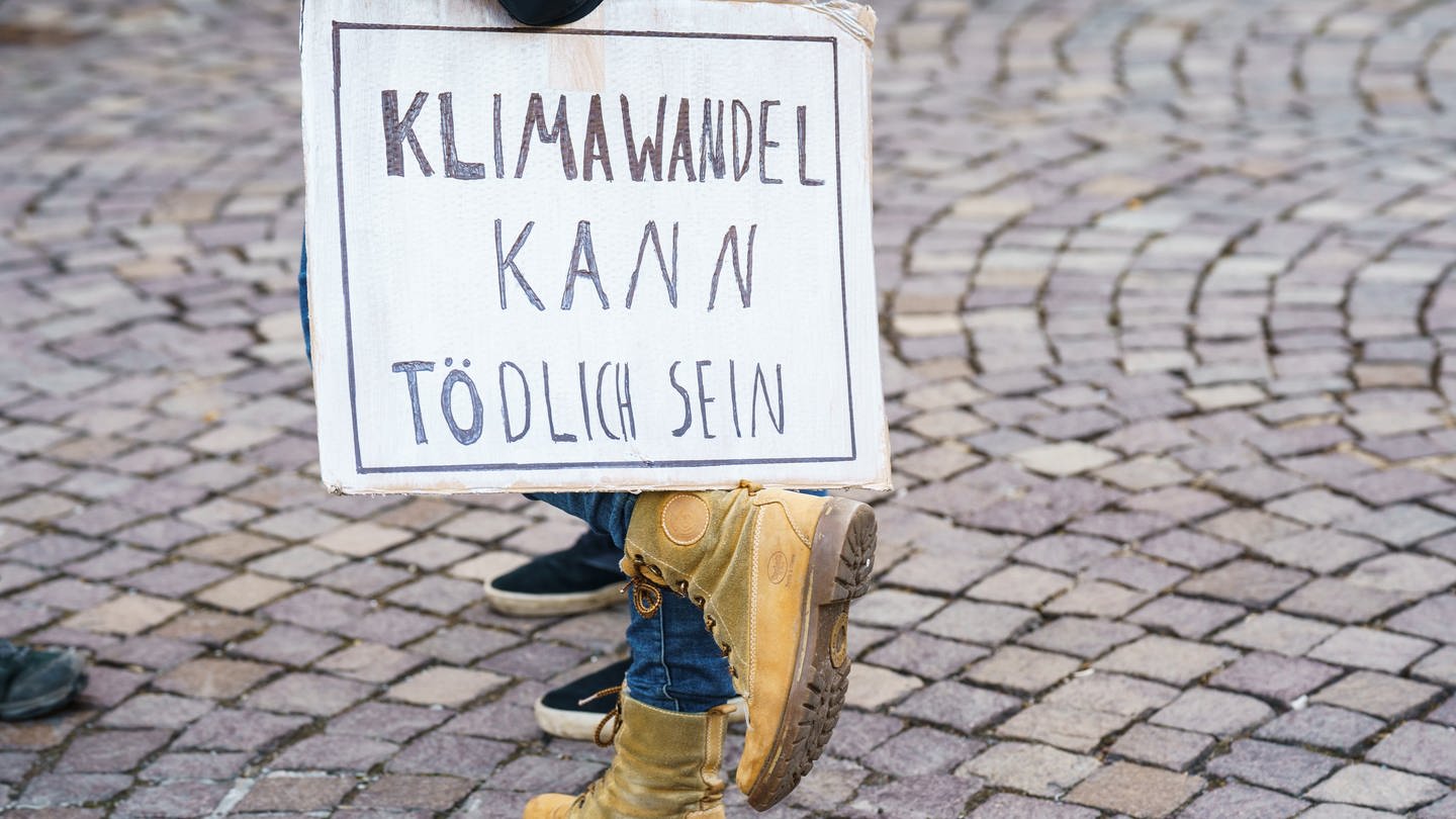 Eine Teilnehmerin des Globalen Fridays for Future Streiks stellt auf ihrem Fuss ein Schild 