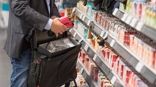 Mann steckt Ware in seine Tasche: Ladendiebstahl im Supermarkt, Discounter und Baumarkt hat wieder stark zugenommen.