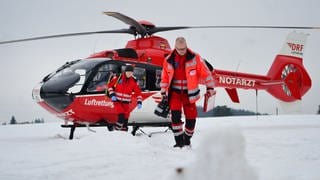 Ein Notarzt und ein Rettungsassistent der Luftrettung DRF sind mit einem Helikopter unterwegs zu einer verunglückten Person