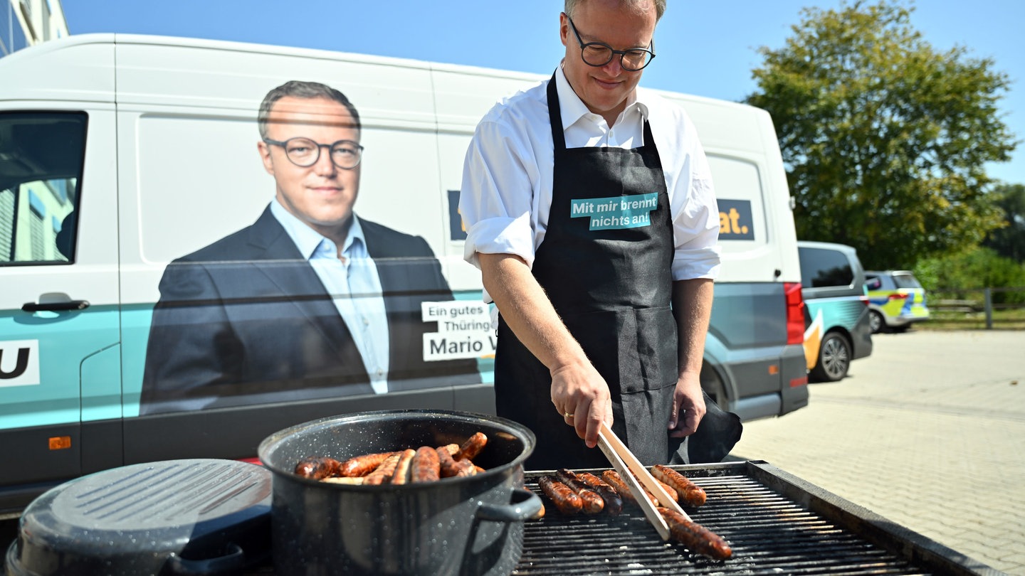 Mario Voigt, CDU, grillt Bratwurst für die Mitarbeiter bei einem Unternehmensbesuch