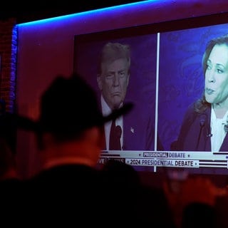 Ein Split-Screen auf einem Fernseher mit Trump und Harris.