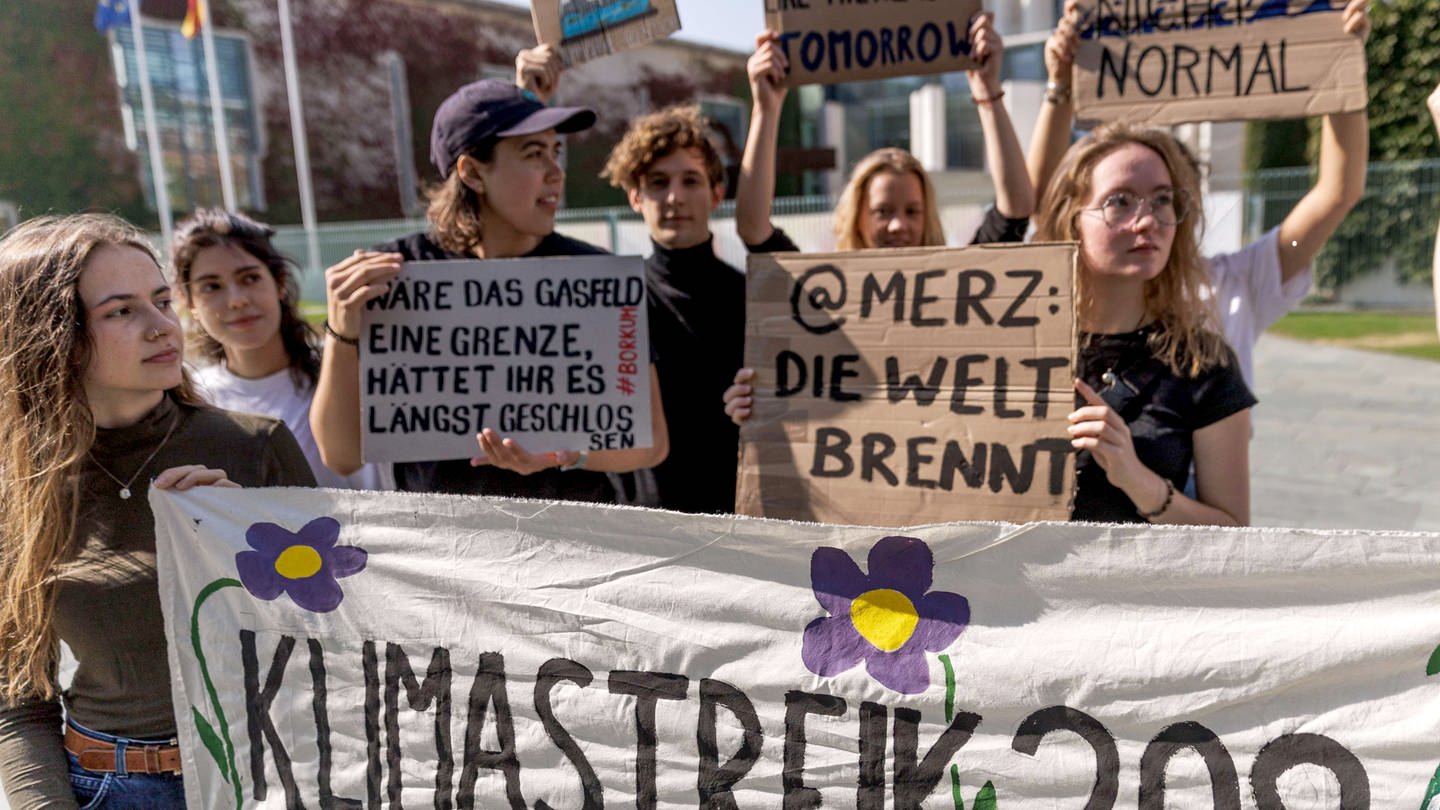 Mitglieder von Fridays for Future Deutschland halten vor dem Bundeskanzleramt bei einer Pressekonferenz zum geplanten globalen Klimastreik am 20. September 2024 ein Transparent mit der Aufschrift 