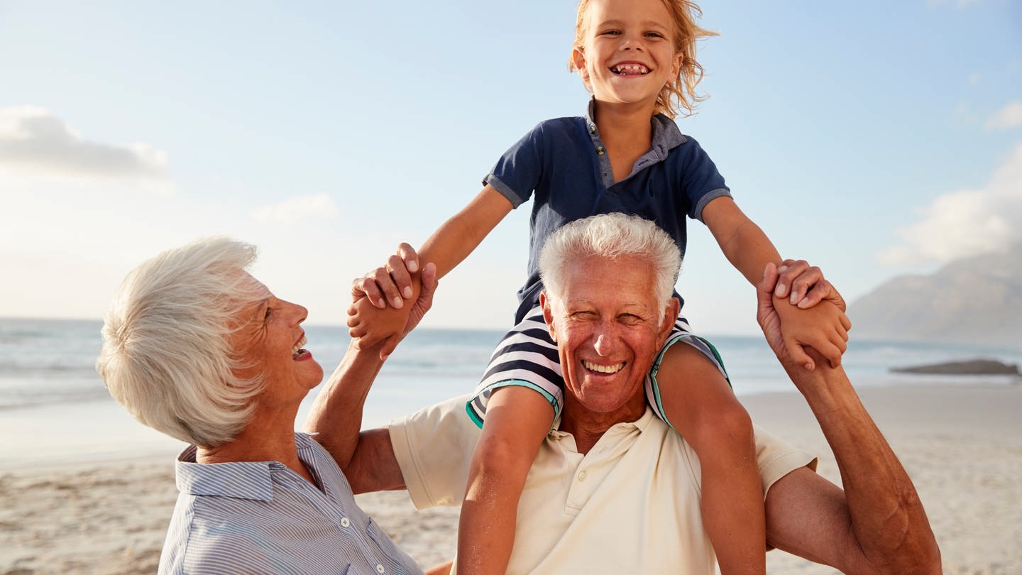 Grandparents Carrying Grandson On Shoulders On Walk Along Beach model released, Symbolfoto, 27.09.2021