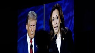 Kamala Harris und Donald Trump sind während des TV-Duells auf einem großen Bildschirm etwas unscharf zu sehen