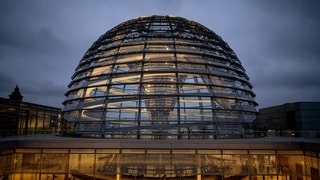 Die Kuppel des Reichstagsgebäudes wird über der Fraktionsebene am Morgen erleuchtet. 