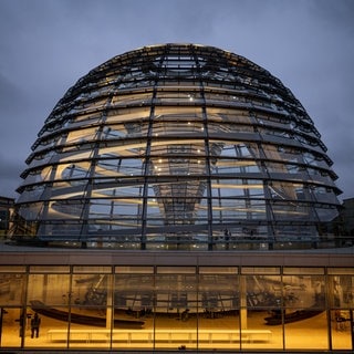 Die Kuppel des Reichstagsgebäudes wird über der Fraktionsebene am Morgen erleuchtet. 