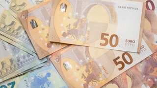 Zahlreiche Euro-Banknoten liegen auf einem Tisch.