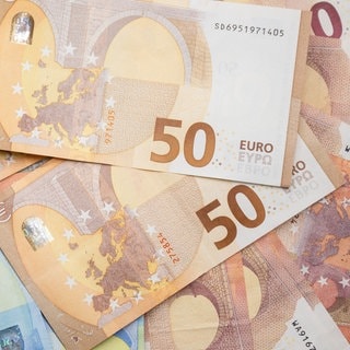 Zahlreiche Euro-Banknoten liegen auf einem Tisch.