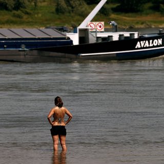 Eine Frau steht im Rhein