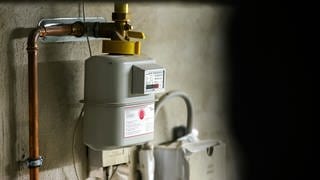 Ein Gaszähler hängt im Keller eines Einfamilienhauses.